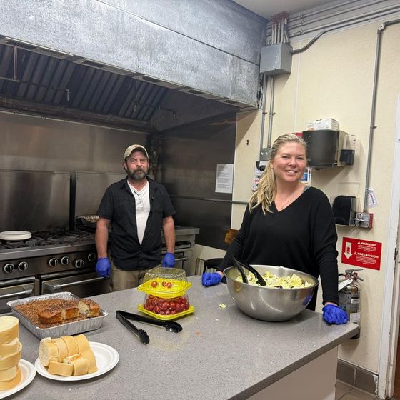 Members at the stove with dinner and dessert ready